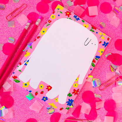 pink notepad with yellow, red and blue flowers