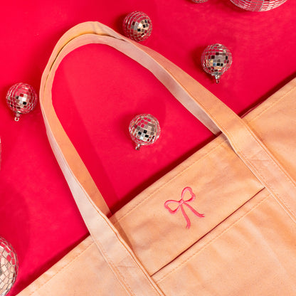 pink bow on beige tote