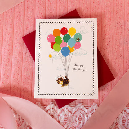 white card with colorful balloons