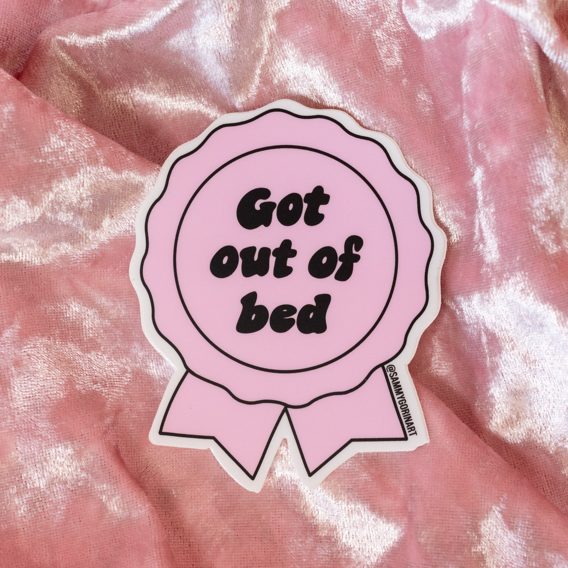 light pink ribbon sticker with black words