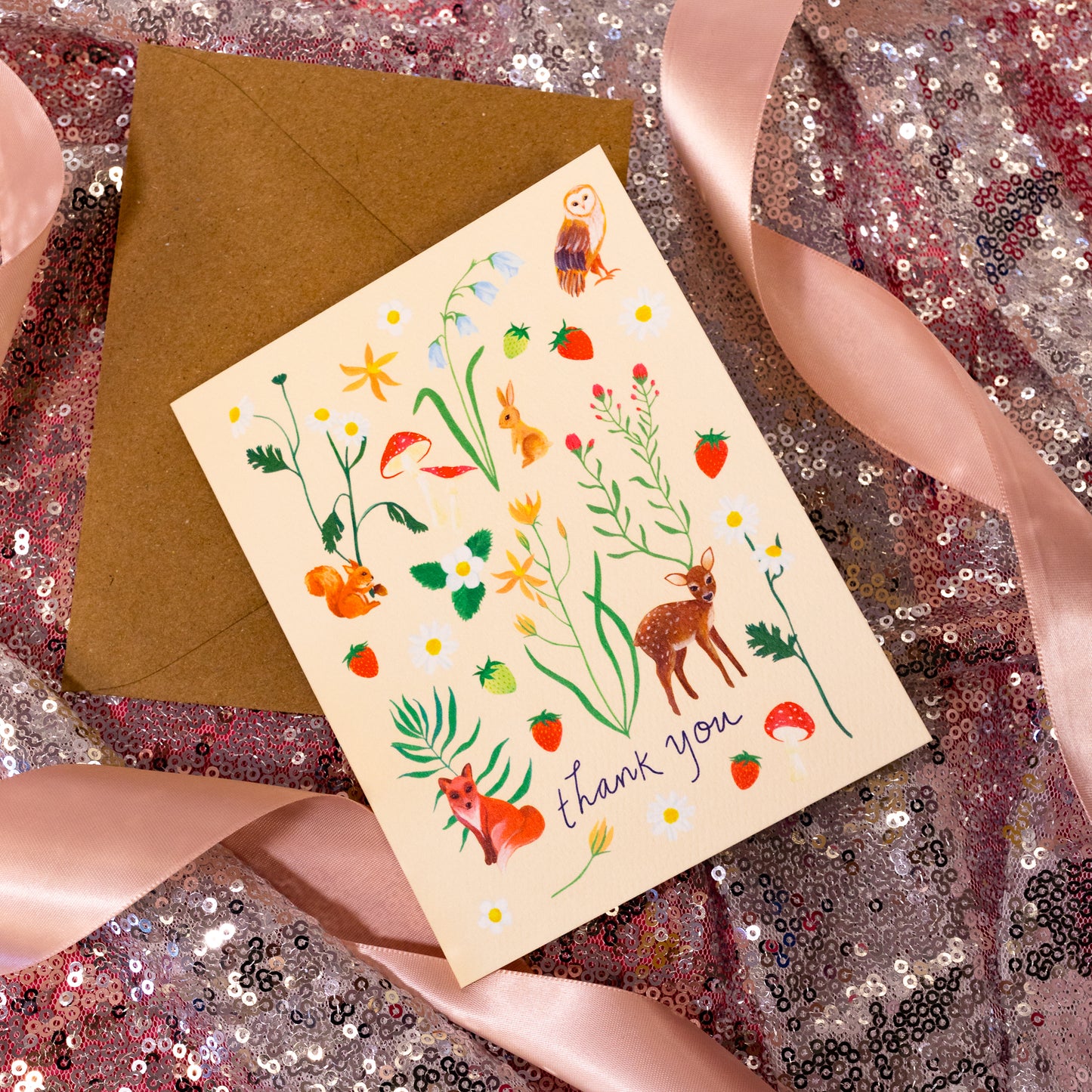 beige card with flowers and animals