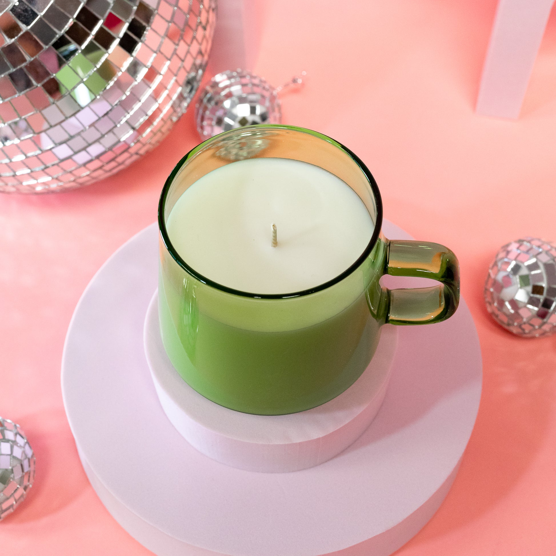 green candle with disco balls
