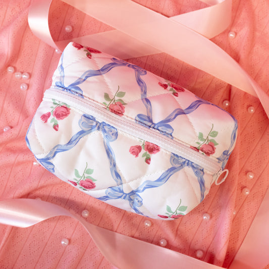 white pouch with blue bows and red roses