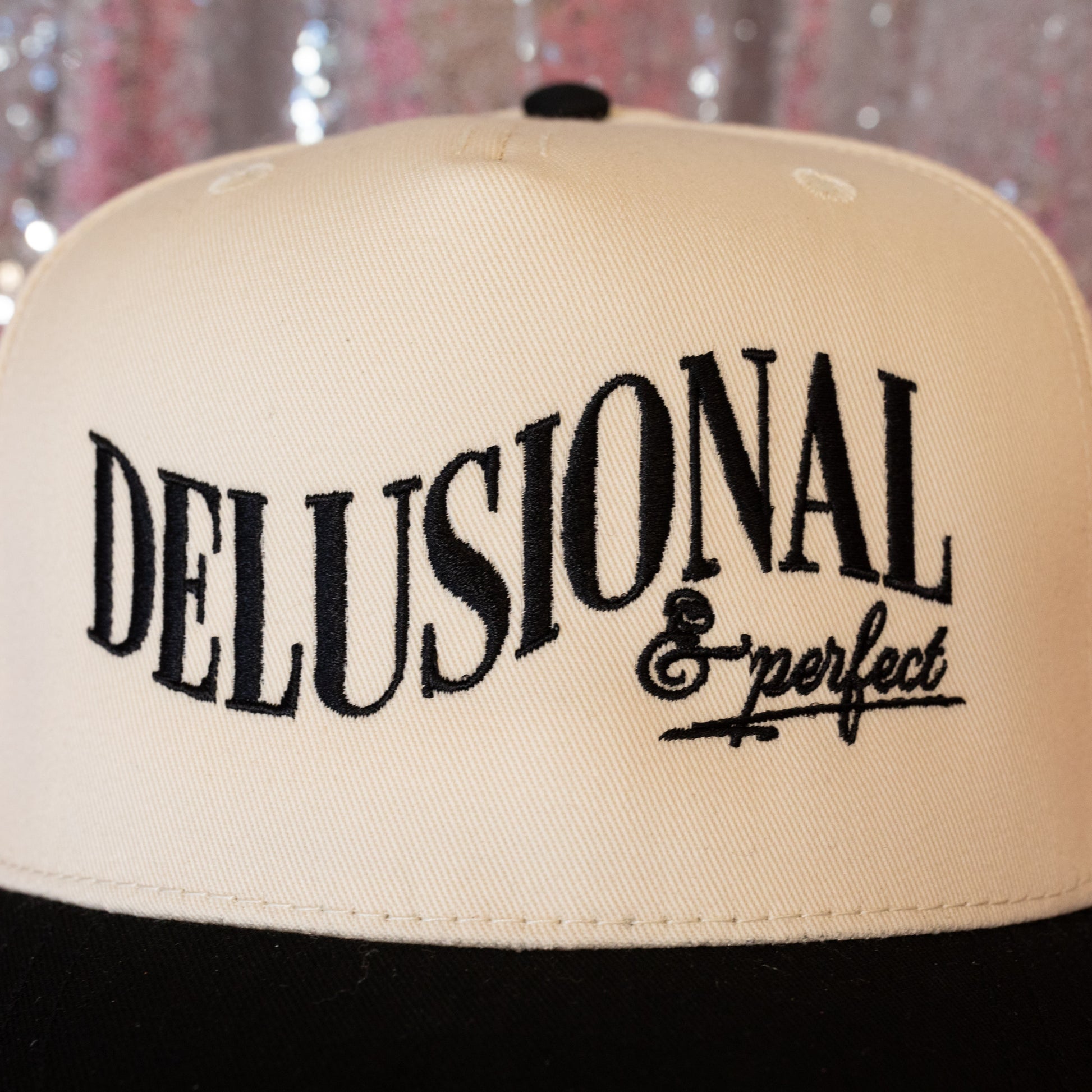 beige hat with delusional in black