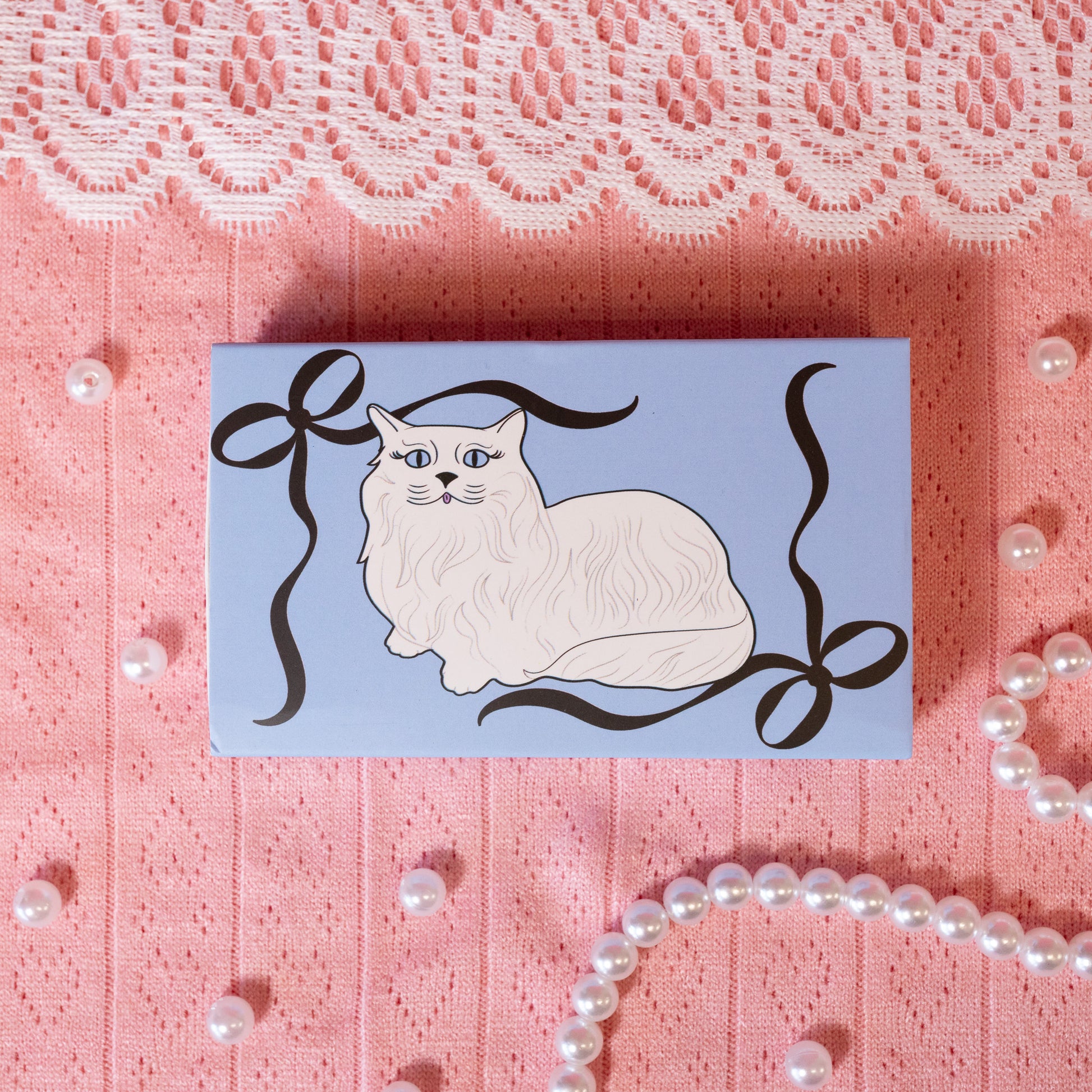 blue matchbook with white cat and black bows