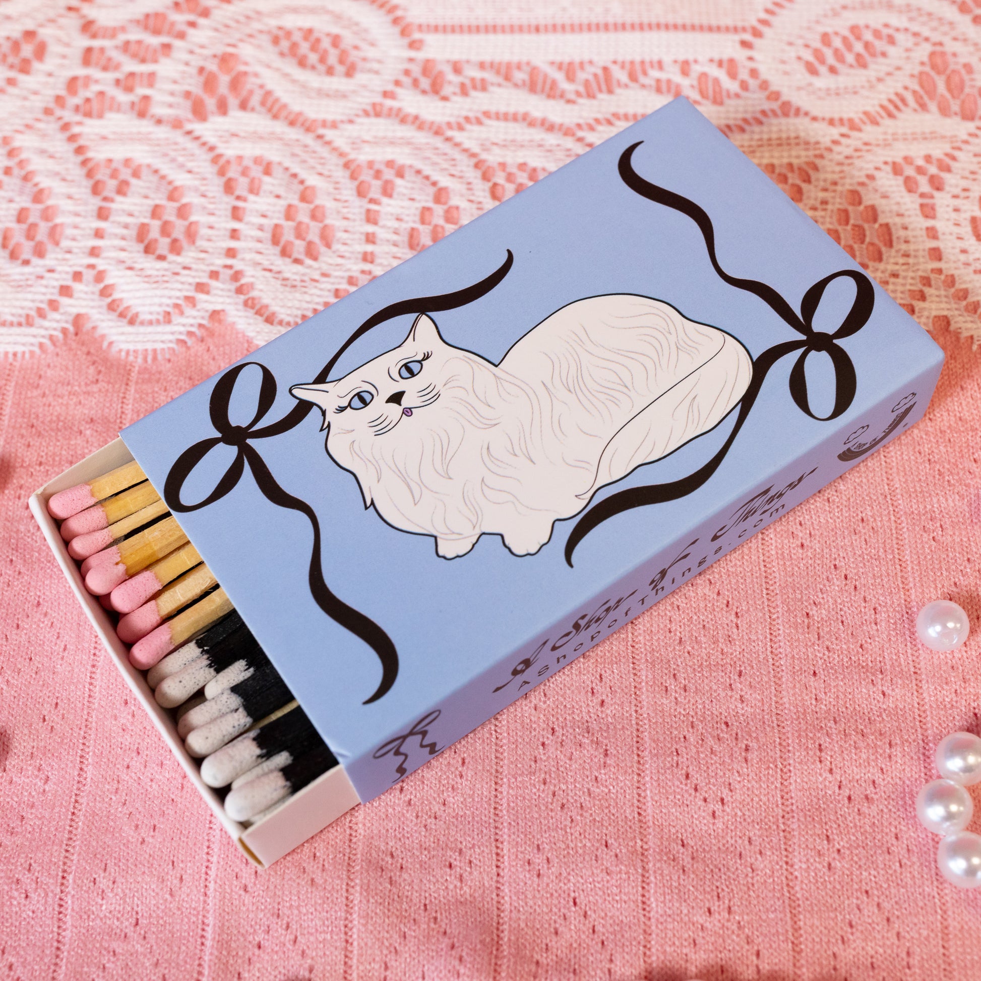 blue matchbox with white cat