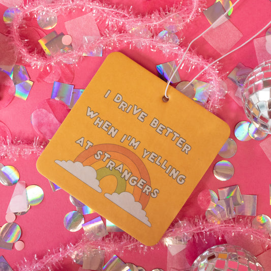 yellow air freshener with rainbow and white words