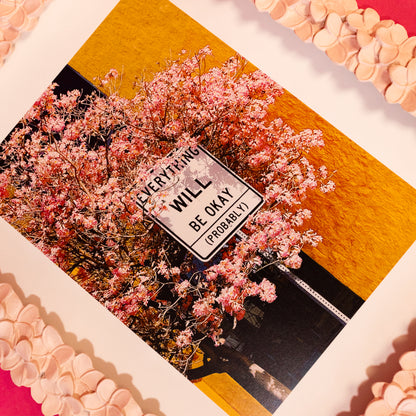 white street sign with pink flowers and orange background