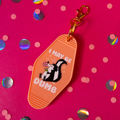 orange keychain with black and white skunk