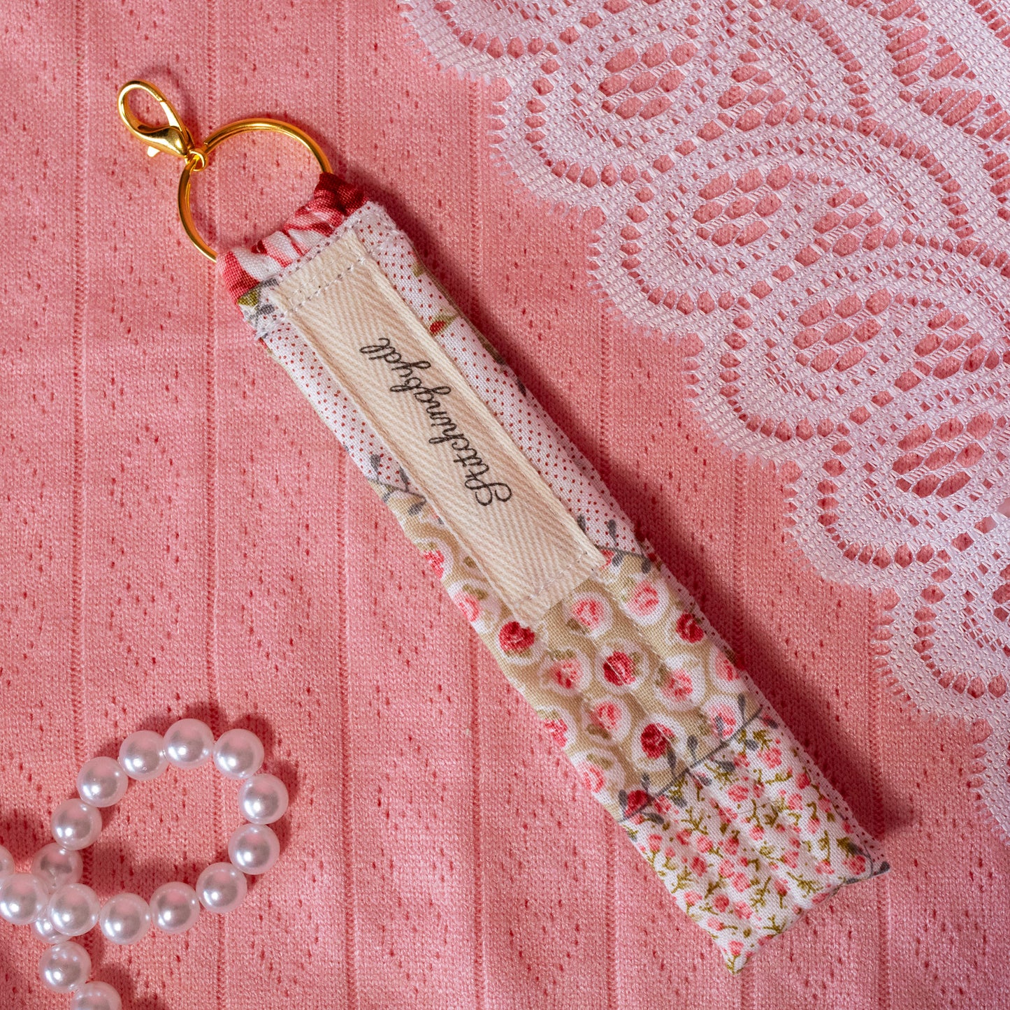 beige tag on pink and red floral keychain