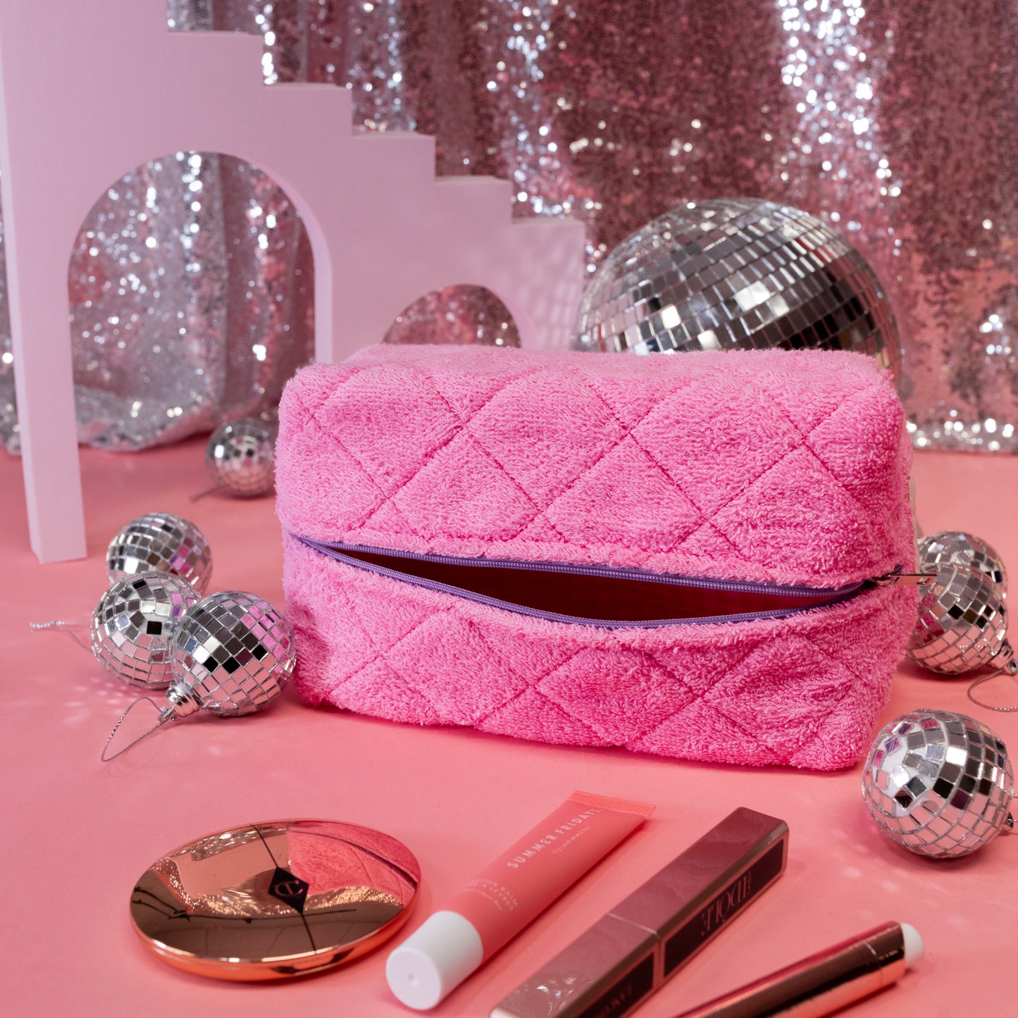 pink makeup bag with makeup and disco balls