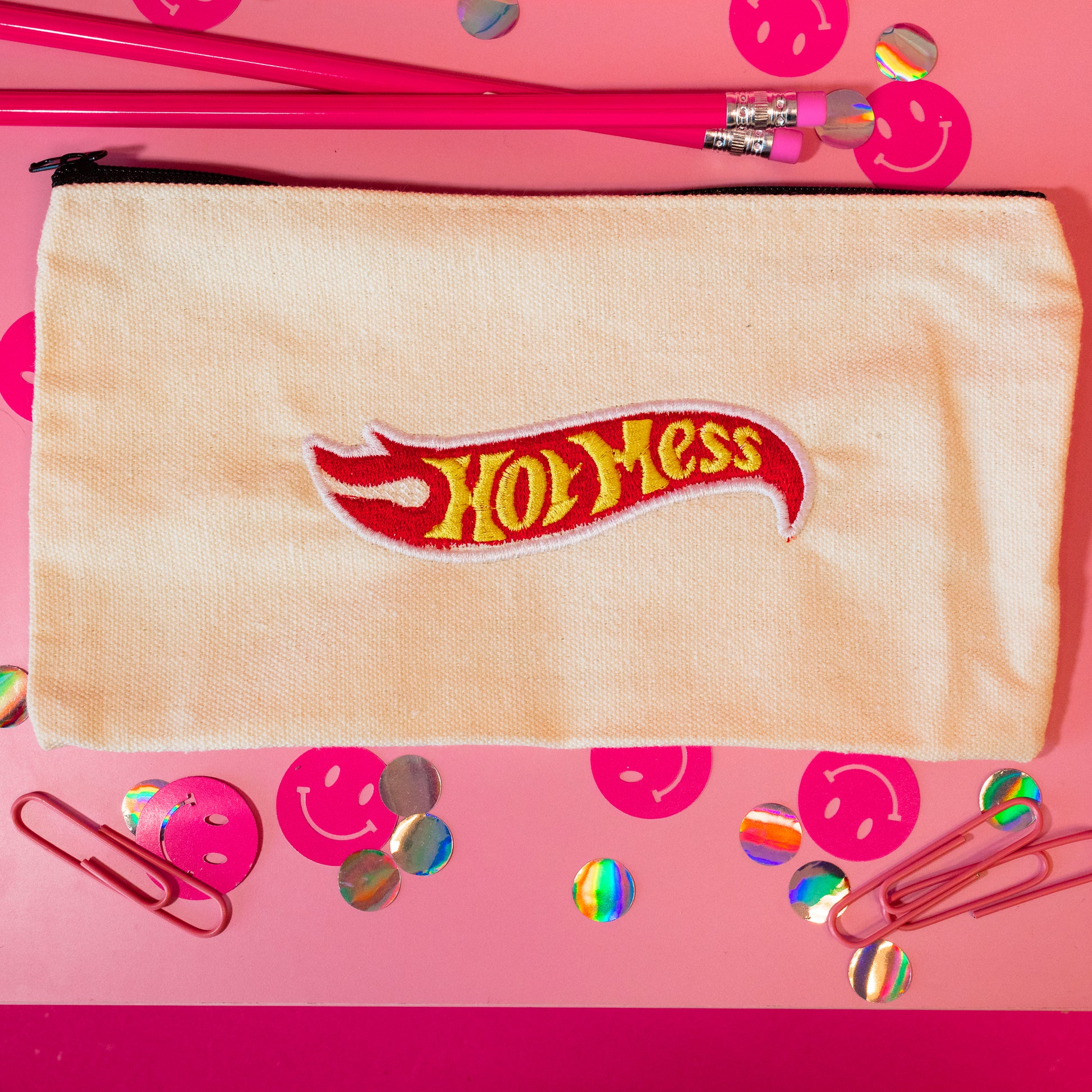 beige pouch with pink flame and yellow words