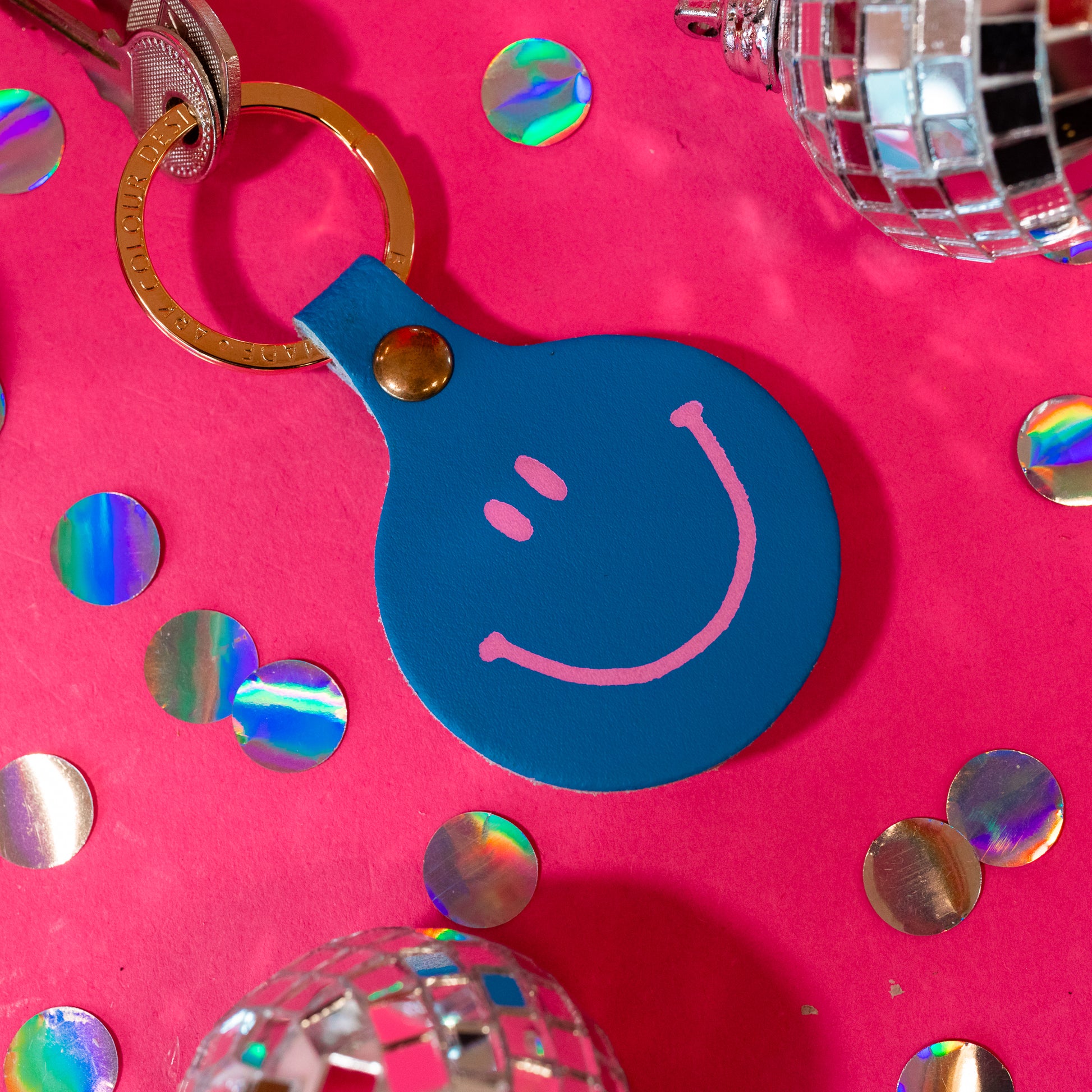 blue keychain with pink smiley face