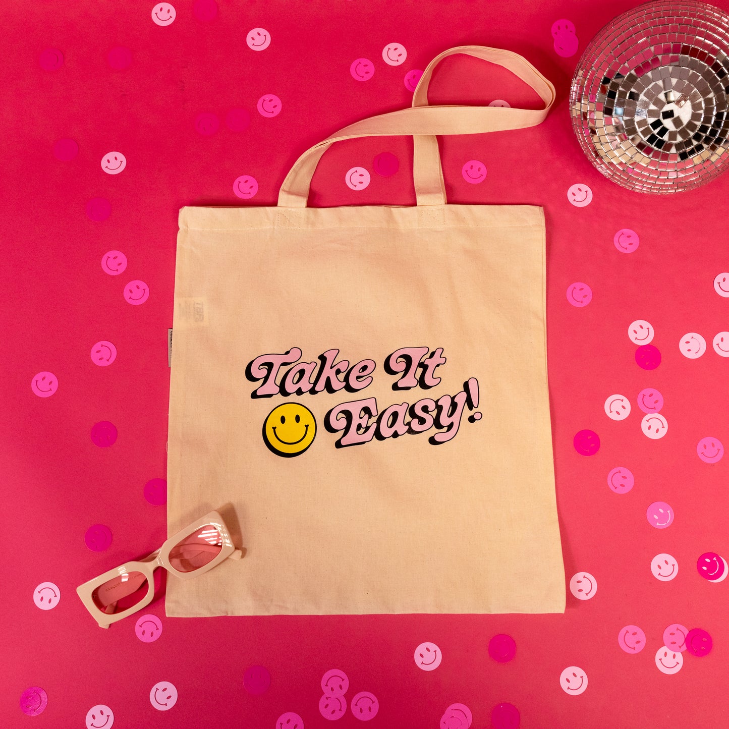 beige tote bag with pink writing
