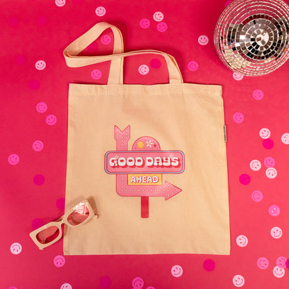 beige tote bag with pink sign