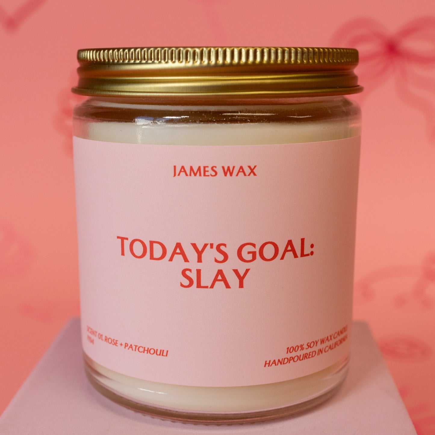 red words on pink jar candle