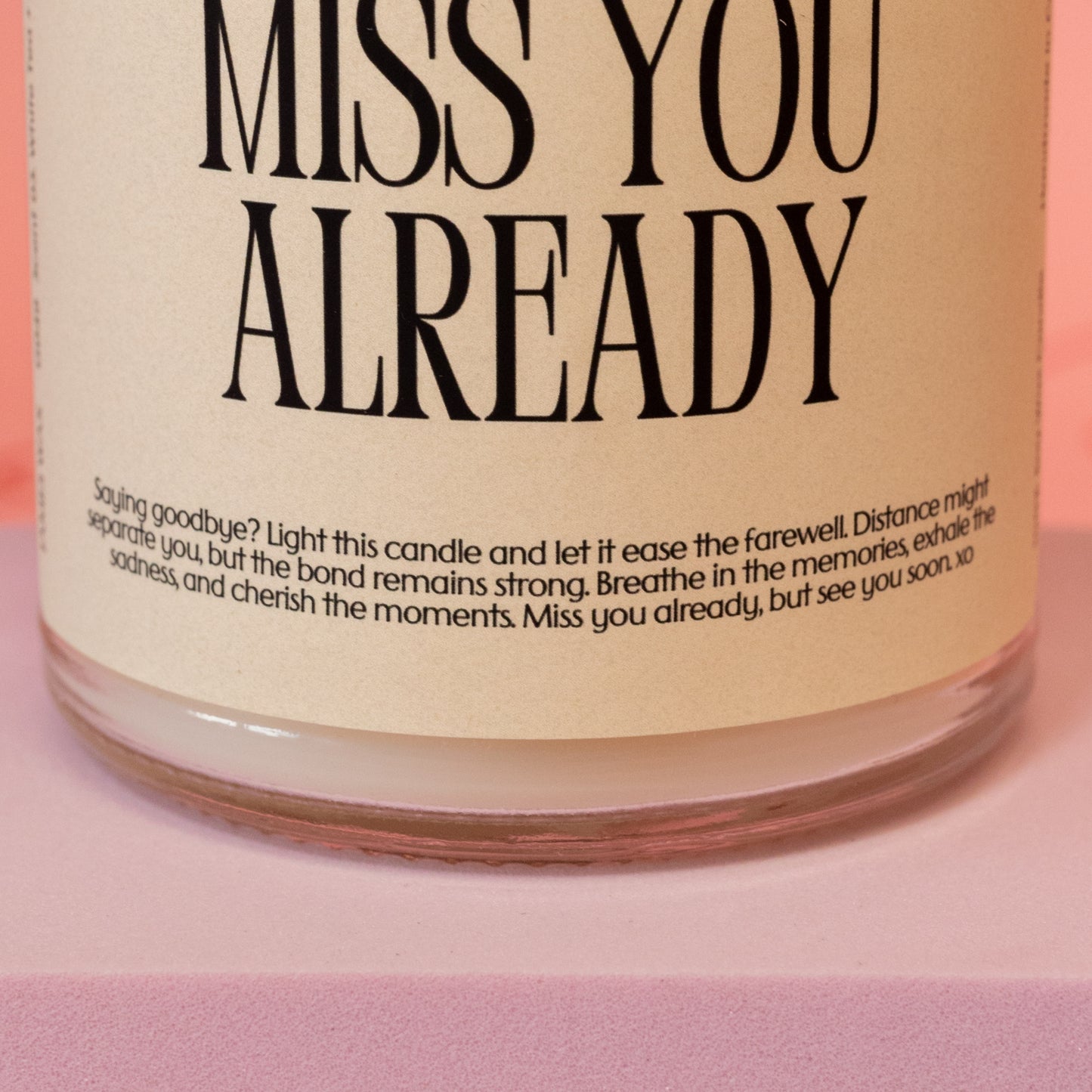 beige candle with black words