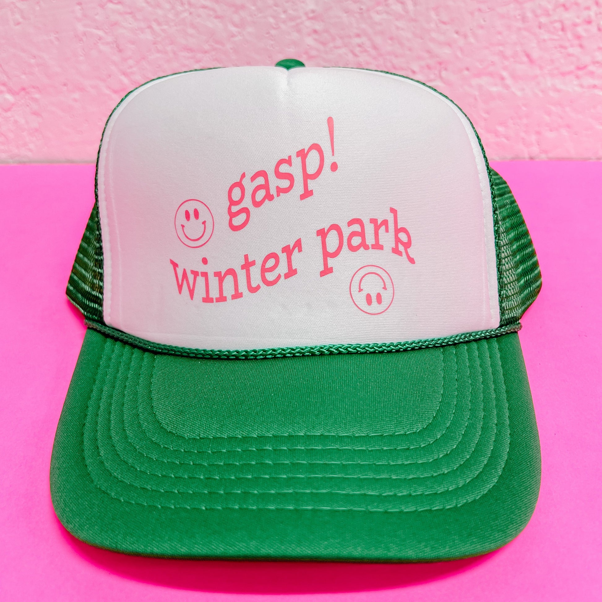 Trendy green and white trucker hat with smiley design.