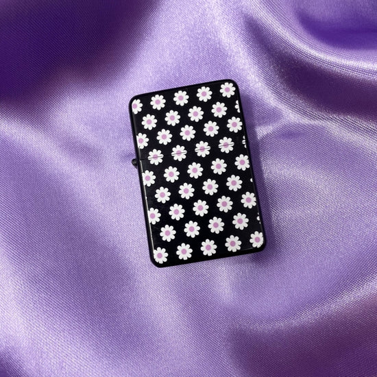Zippo style refillable lighter that has purple and white daisies.